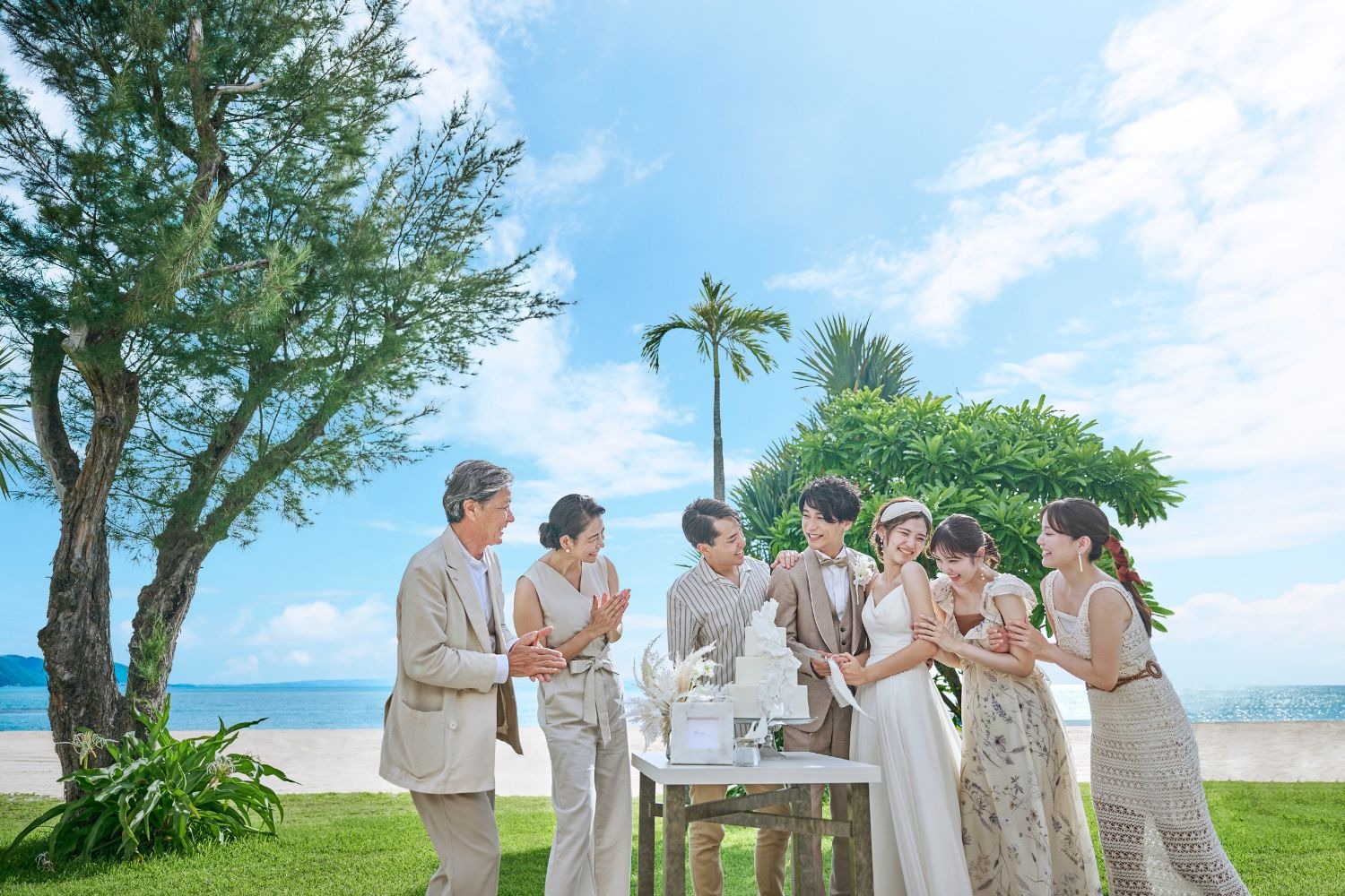 笑顔でケーキ入刀する新郎新婦とゲスト